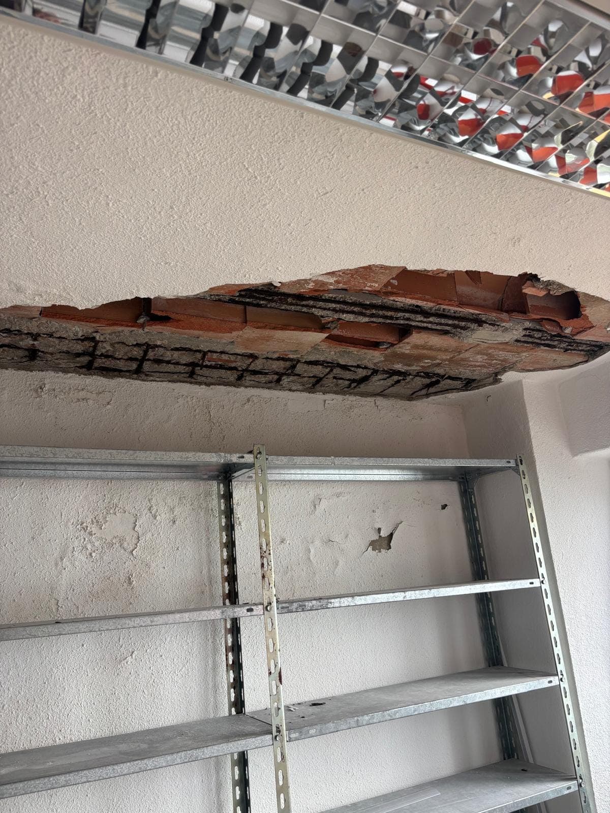 Techo con el revestimiento caído y la armadura del forjado a la vista