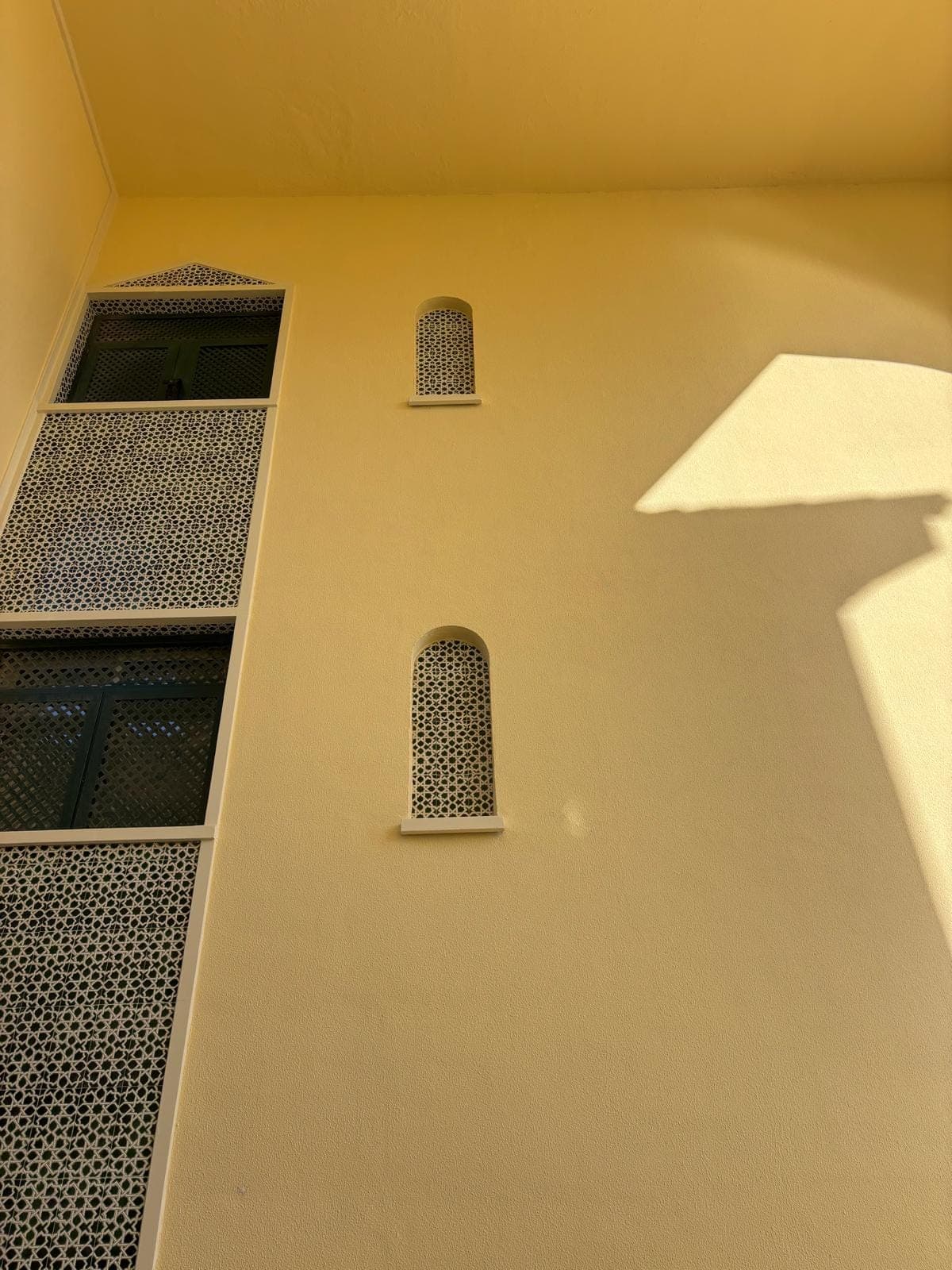 Fachada con celosías cerámicas y ventana en arco, ya rehabilitada